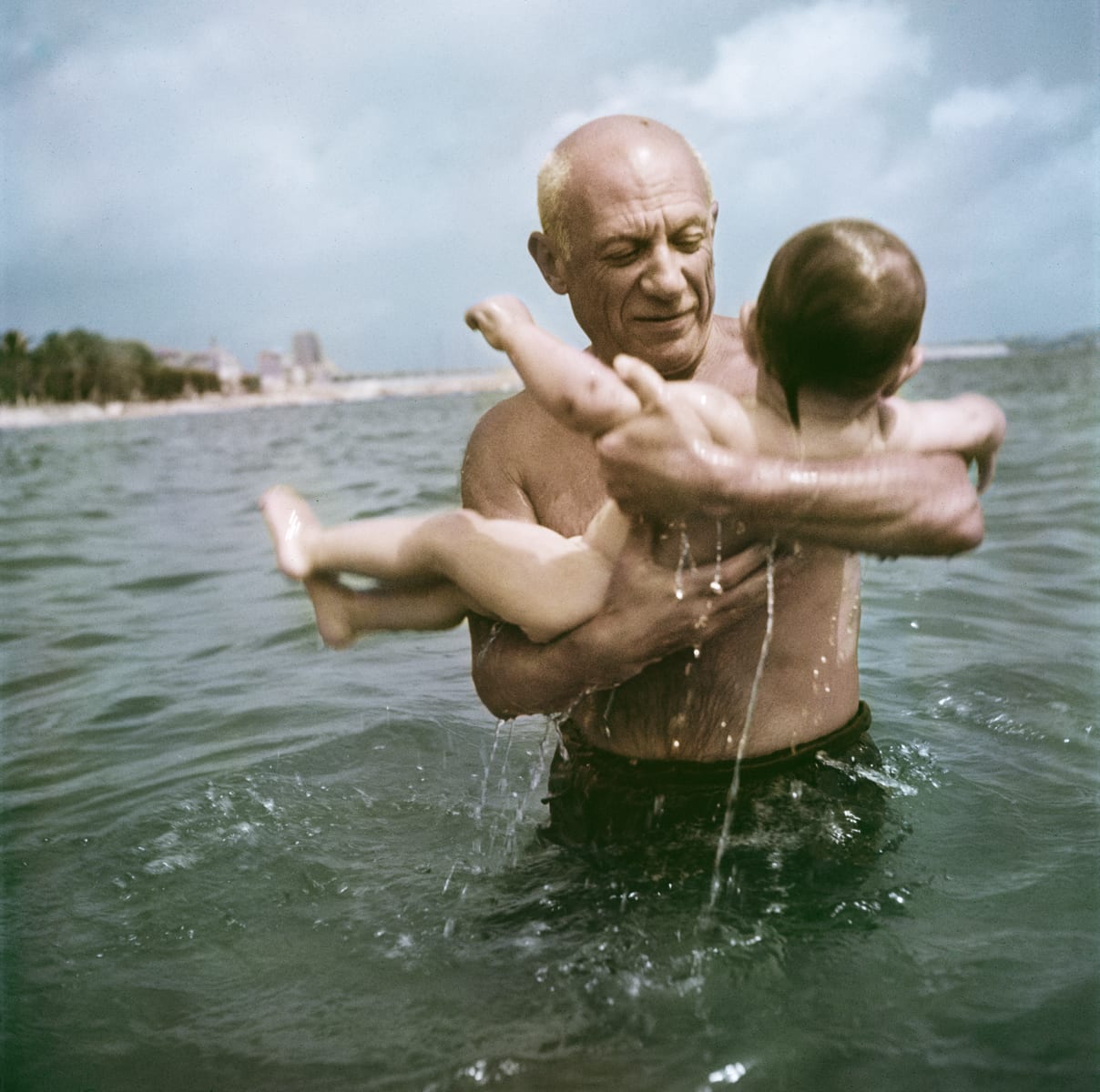 Pablo Picasso playing in the water with his son Claude, Vallauris, France, 1948. © Robert Capa/International Center of Photography/Magnum Photos.
