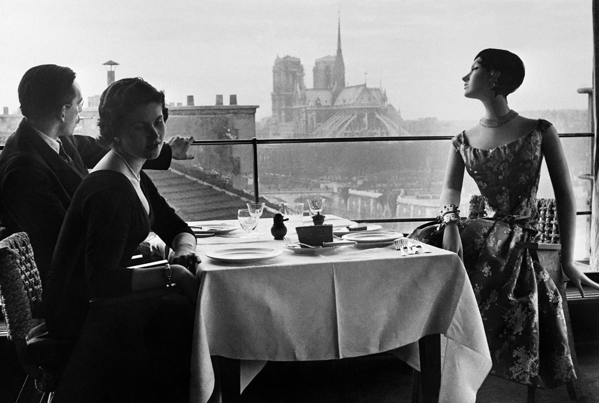 1WR888 Le mannequin Francine pose lors d’un shooting devant un modèle de cire au restaurant La Tour d’Argent, le 24 février 1955, avec vue sur la cathédrale Notre-Dame de Paris