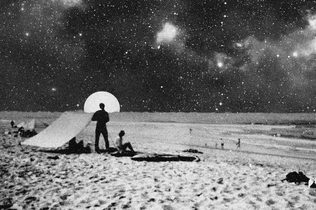 Une photo en noir et blanc de deux silhouettes dans le désert face à la lune