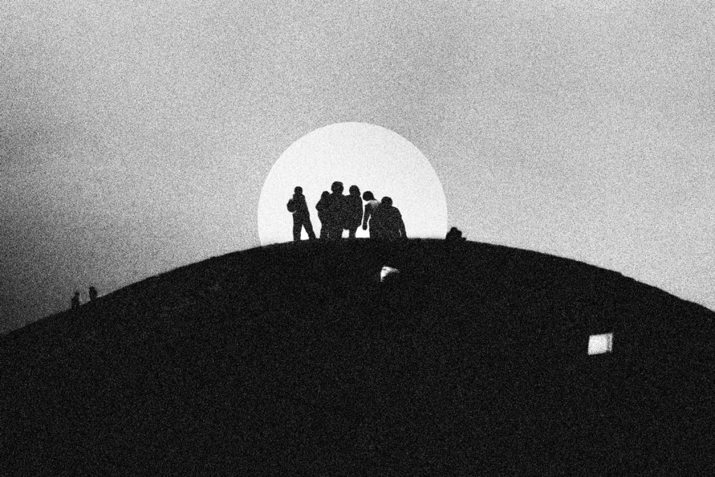 Des silhouettes humaines encerclées par la lune. Noir et blanc