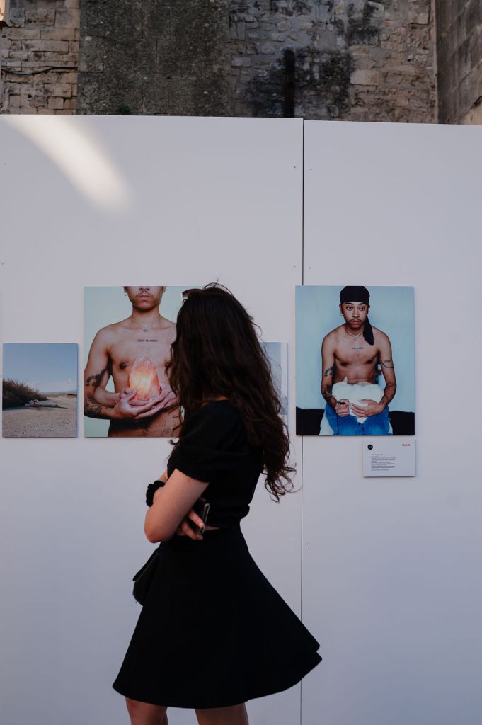 Jeune femme devant l'exposition 10/10, cour de l'Archevêché, durant les Rencontres d'Arles