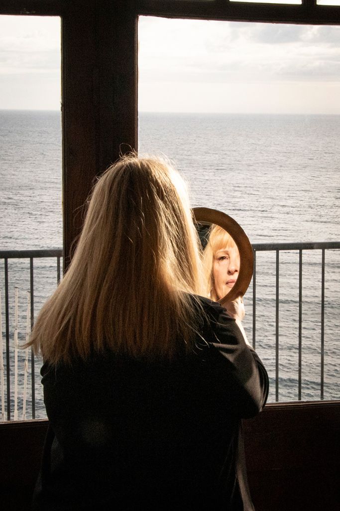 Photographie réalisée par Marjorie Gosset montrant une femme face à la mer, se regardant dans un miroir.