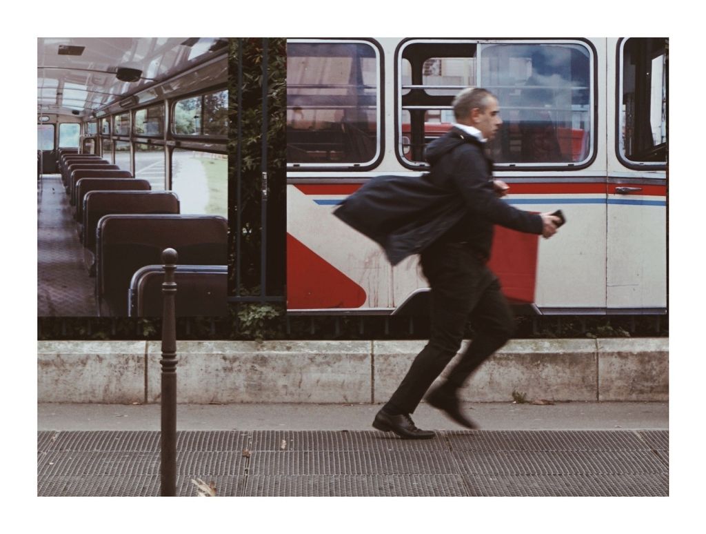 Un homme court devant des affiches représentant des trains