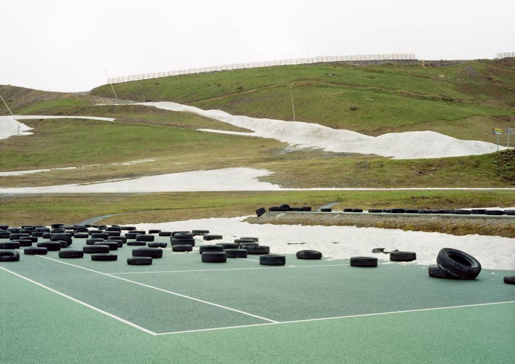 Un terrain de tennis au bord d'une colline à moitié enneigée