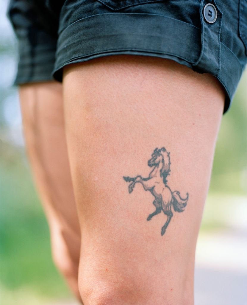 Photographie de Kati Leinonen montrant un tatouage de cheval sur une cuisse