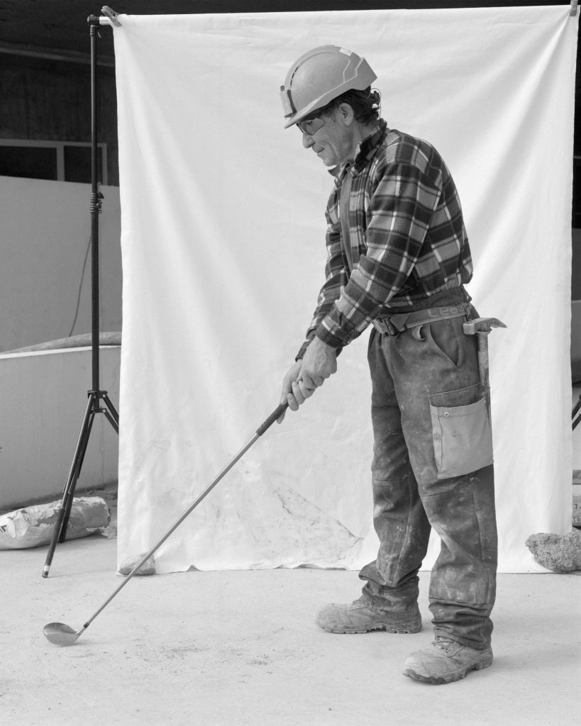 Ouvrier de chantier qui joue au golf.