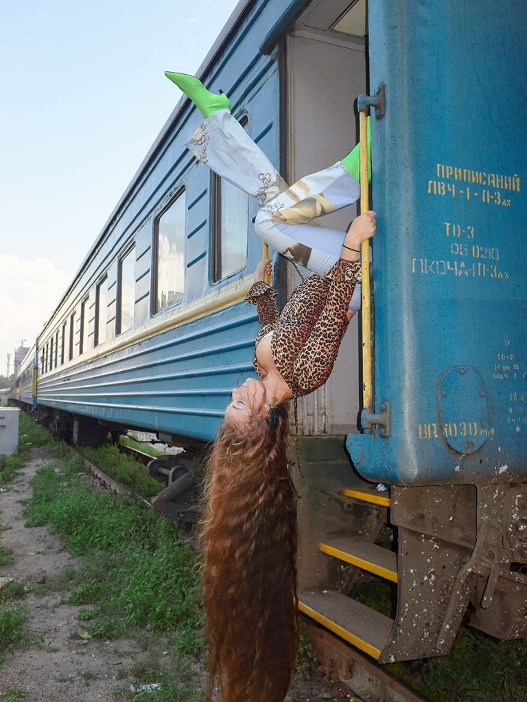 femme suspendue à la porte d'un train