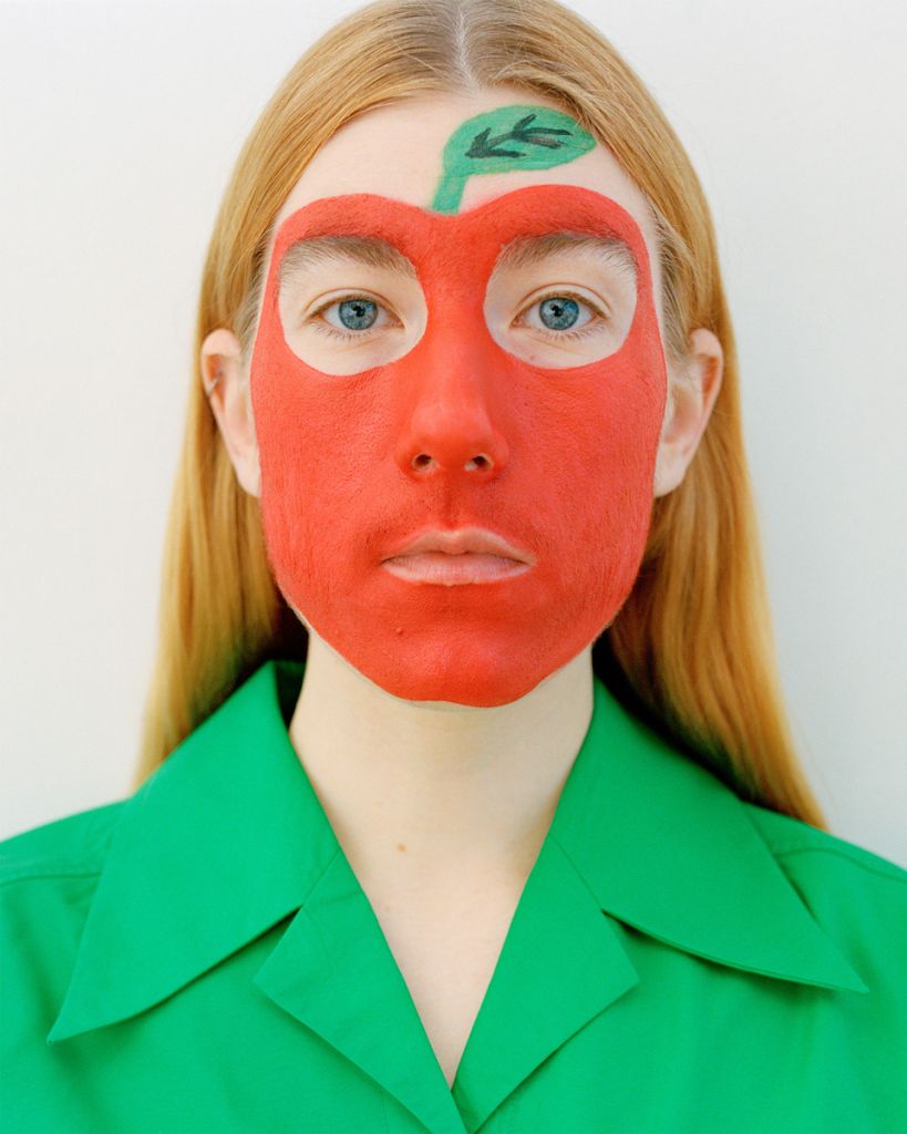 Autoportrait d'Emma Serpaniemi avec une pomme dessinée sur le visage