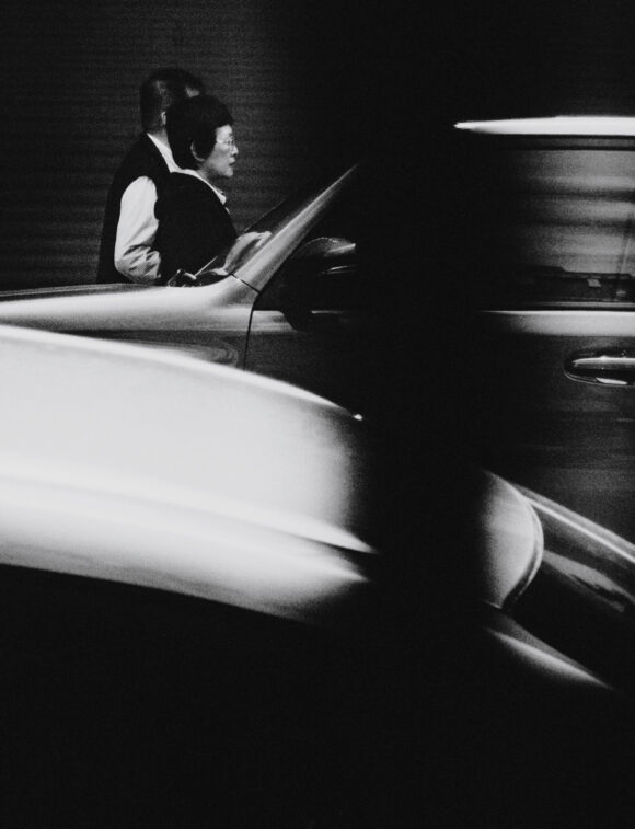 couple dans la rue passant devant une voiture