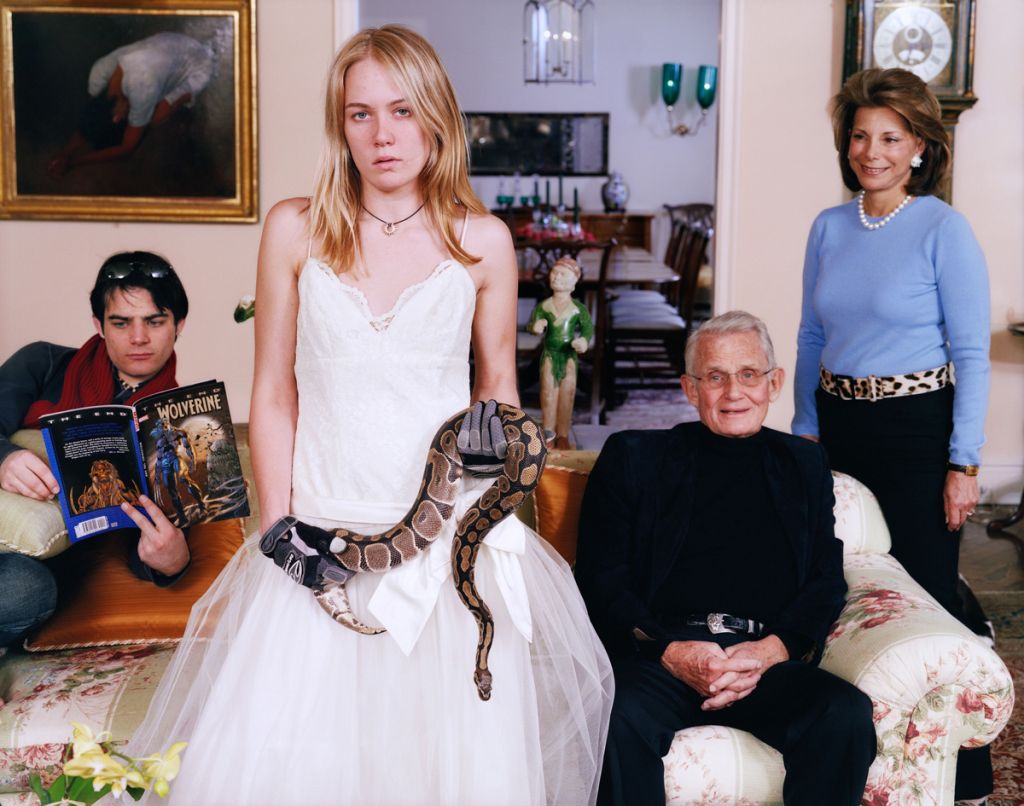 Photographie de Tina Barney montrant une famille dont la fille, en robe blanche, tient un serpent