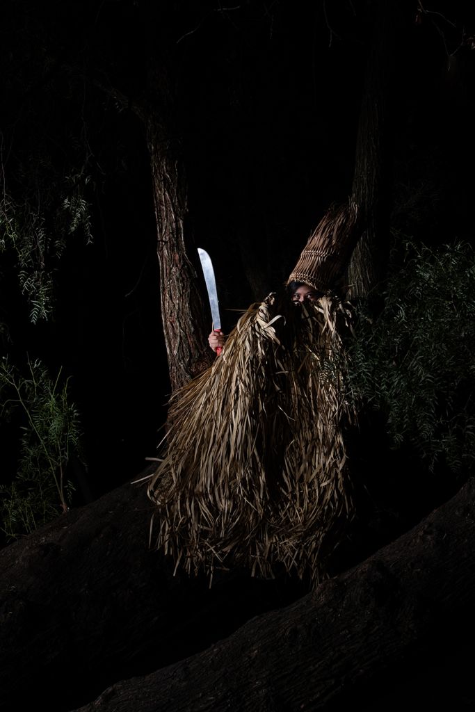 homme en tenue traditionnelle avec une machète