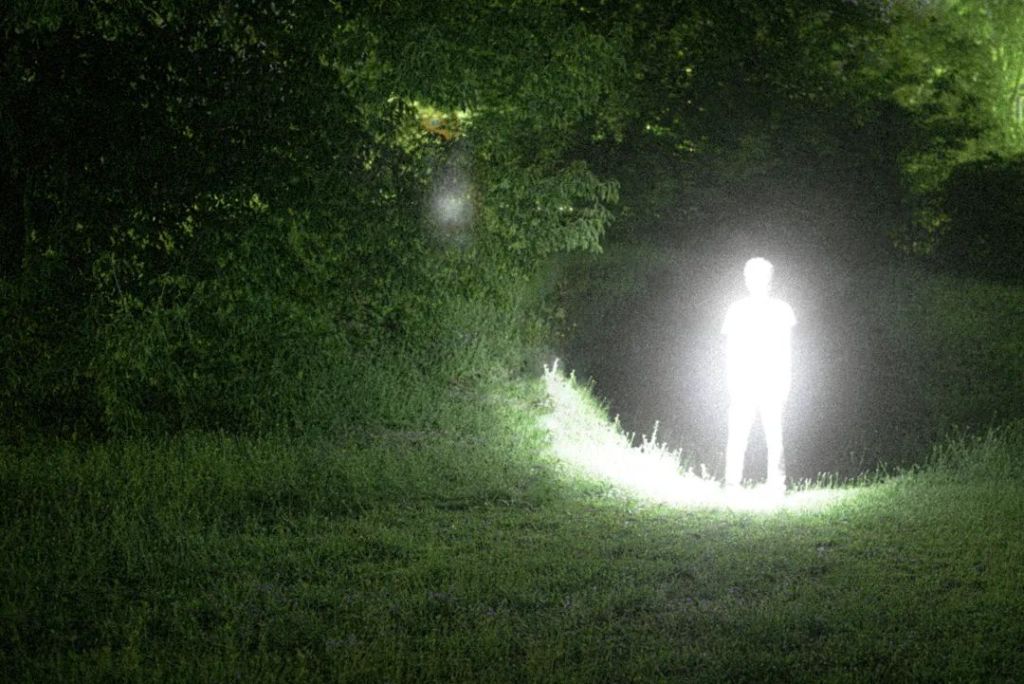 Personne debout très illuminée dans un paysage